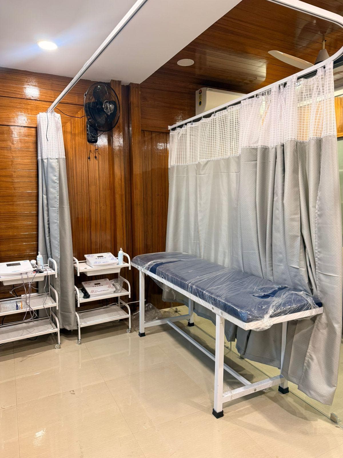 Curtained treatment bay with electrotherapy equipment at VedaKinetics